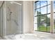 Bright bathroom showcasing a bathtub and a shower with a view of the outdoors through a large window at 9397 Merriweather Dr, Weeki Wachee, FL 34613