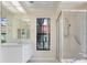 Bright bathroom featuring a white vanity, frameless shower, and a window view at 9397 Merriweather Dr, Weeki Wachee, FL 34613