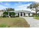 Charming single-story home featuring a well-manicured lawn and long paved driveway at 9397 Merriweather Dr, Weeki Wachee, FL 34613