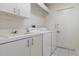 Well-lit laundry room featuring front loading washer and dryer plus storage at 9397 Merriweather Dr, Weeki Wachee, FL 34613