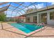 The large screened in pool is surrounded by brick pavers and overlooks the backyard at 9397 Merriweather Dr, Weeki Wachee, FL 34613