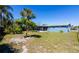 Serene backyard with a screened-in patio, lush tropical trees and well-maintained lawn at 10245 Regency Park Blvd, Port Richey, FL 34668