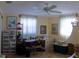 Functional bedroom with carpet flooring, a ceiling fan, a desk with a chair, and natural light at 10245 Regency Park Blvd, Port Richey, FL 34668