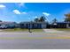 Clear view of the blue home and its well-manicured lawn with a private driveway at 10245 Regency Park Blvd, Port Richey, FL 34668