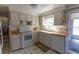 Traditional kitchen with white appliances, a double basin sink, tile flooring, and natural light at 10245 Regency Park Blvd, Port Richey, FL 34668
