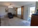 Inviting living room featuring neutral carpet, a ceiling fan, and a large window for natural light at 10245 Regency Park Blvd, Port Richey, FL 34668