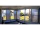 Enclosed sunroom with ample windows offering backyard views; perfect for relaxing or entertaining guests at 10245 Regency Park Blvd, Port Richey, FL 34668