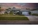 Twilight view of a home with a landscaped yard and a well-lit front entrance at 10407 Audie Brook Dr, Spring Hill, FL 34608