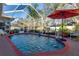 Enclosed pool area with a red-brick surround, an umbrella and tropical plants at 1086 Hook Dr, Spring Hill, FL 34608