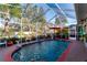 Screened-in swimming pool with crystal clear water surrounded by mature landscaping at 1086 Hook Dr, Spring Hill, FL 34608