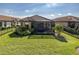 A fenced backyard featuring a lush lawn and screened patio, creating a private and serene outdoor living space at 11383 Callisia Dr, Odessa, FL 33556