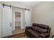 Cozy bedroom featuring barn doors to the bathroom, and a comfortable leather reclining couch at 11383 Callisia Dr, Odessa, FL 33556