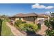 Side view of a one-story home with manicured shrubs, landscaping and a paver walkway at 11383 Callisia Dr, Odessa, FL 33556