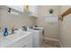 Bright laundry room with white cabinets, sink, modern appliances and drying rack at 11383 Callisia Dr, Odessa, FL 33556