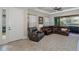 Comfortable living room featuring a leather sectional sofa, ceiling fan, and sliding glass doors at 11383 Callisia Dr, Odessa, FL 33556