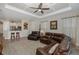 Living room featuring a leather sectional sofa, ceiling fan, and an open floorplan to the kitchen at 11383 Callisia Dr, Odessa, FL 33556