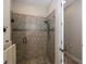 Walk-in shower with large neutral tile and frameless glass door at 11383 Callisia Dr, Odessa, FL 33556