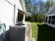 Side yard featuring an A/C unit, grass, and part of the house visible in the background at 12114 Clearbrook Ln, Hudson, FL 34667