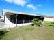 Exterior view of the screened sunroom and well-maintained lawn at 12114 Clearbrook Ln, Hudson, FL 34667