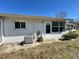 Exterior home view featuring sliding glass door to the sunroom, an air conditioning unit, and landscaped yard at 12205 Darwood Dr # 12205, Hudson, FL 34667