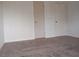 This bedroom is a blank canvas with neutral-colored walls, gray carpeting, and dual closets at 12401 Joel Ct, Tampa, FL 33612