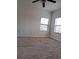 Bright bedroom featuring neutral carpet, a ceiling fan, and ample natural light from two windows at 12401 Joel Ct # 1, Tampa, FL 33612