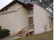 Exterior view of a townhouse, featuring a private entrance with wooden steps at 12401 Joel Ct, Tampa, FL 33612