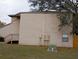Exterior side view of a townhouse with stairs, electrical boxes, and a small window at 12401 Joel Ct, Tampa, FL 33612