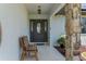 Inviting front porch features a decorative front door, stone pillar, and a charming wooden bench at 13415 Ester Dr, Brooksville, FL 34613