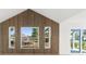 Close-up of a wood-slatted accent wall with large windows offering scenic views at 13726 Michelle Ave, Hudson, FL 34667