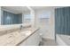Modern bathroom featuring granite countertops, contemporary fixtures, and blue tile accent wall at 13726 Michelle Ave, Hudson, FL 34667