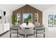 Modern dining room with a statement accent wall, sleek furniture, and natural light streaming through large windows at 13726 Michelle Ave, Hudson, FL 34667