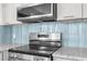 Stainless steel range with subway tile backsplash and granite countertops at 13726 Michelle Ave, Hudson, FL 34667