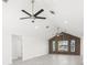 Bright living room with vaulted ceilings, modern ceiling fans, and unique wood accent wall with large windows at 13726 Michelle Ave, Hudson, FL 34667