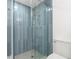 Modern bathroom with a glass-enclosed shower and mosaic tile flooring at 13726 Michelle Ave, Hudson, FL 34667