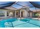 Screened-in pool area with blue tiled pool, patio, and views of the backyard at 14251 Mansfield Rd, Spring Hill, FL 34609