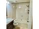 Bathroom with white tile shower and tub, granite sink, and updated fixtures at 14736 Norwood Oaks Dr # 103, Tampa, FL 33613