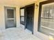 Inviting front entrance with secure black door, tiled floor, and framed windows for natural lighting at 14736 Norwood Oaks Dr # 103, Tampa, FL 33613