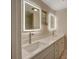 Bright bathroom featuring double sinks, illuminated mirrors, and granite countertops at 14821 Sassandra Dr, Odessa, FL 33556