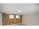 Bedroom featuring a stylish brick accent wall, neutral paint, and ample natural light, creating a cozy atmosphere at 14821 Sassandra Dr, Odessa, FL 33556