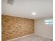 Bedroom with brick wall, light wood floors and a bright window at 14821 Sassandra Dr, Odessa, FL 33556