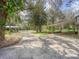 Wide driveway leading to a house with a carport and lush surroundings at 14821 Sassandra Dr, Odessa, FL 33556