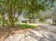 Charming single-story home featuring a spacious front yard and mature trees providing ample shade and curb appeal at 14821 Sassandra Dr, Odessa, FL 33556