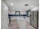 Beautiful kitchen with white cabinets, stainless steel appliances, island with marble countertop, and blue backsplash at 14821 Sassandra Dr, Odessa, FL 33556