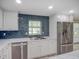 Kitchen with white cabinets, marble countertops, stainless steel appliances, and a stainless steel sink with a blue backsplash at 14821 Sassandra Dr, Odessa, FL 33556