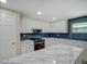Elegant kitchen featuring white cabinets, marble countertops, stainless steel appliances, and stylish blue backsplash at 14821 Sassandra Dr, Odessa, FL 33556