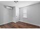 Empty bedroom featuring hardwood floors, white walls and trim, with window and ceiling fan at 15188 Riverside Ln, Nobleton, FL 34661