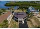 Aerial view of the waterfront property with a unique architectural design and lush landscaping at 1616 Sea Breeze Dr, Tarpon Springs, FL 34689