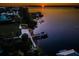 Sunset aerial view of home with dock along waterfront, showcasing the property's serene and private location at 1616 Sea Breeze Dr, Tarpon Springs, FL 34689