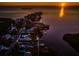 Breathtaking aerial view of waterfront homes on a peninsula, reflecting the sunset over the ocean at 1616 Sea Breeze Dr, Tarpon Springs, FL 34689